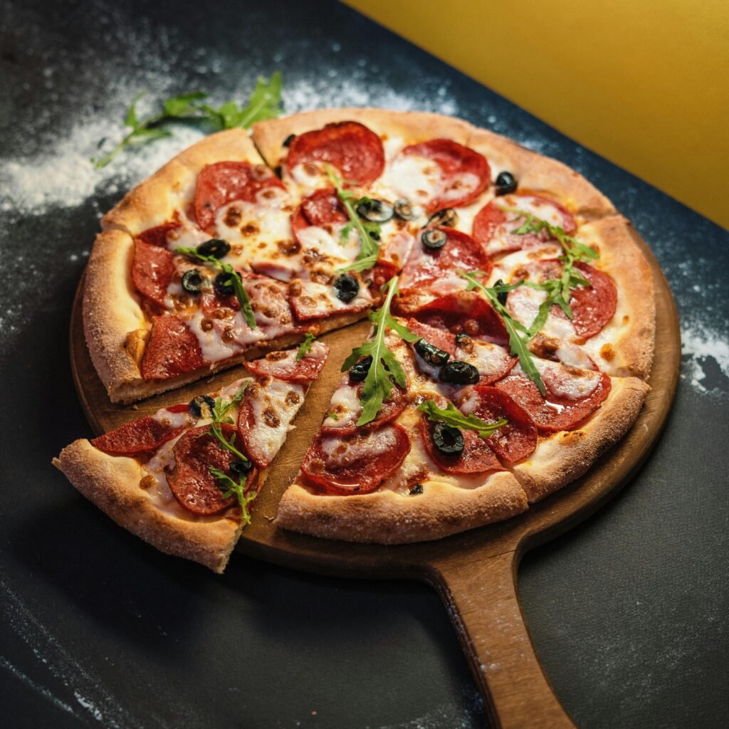 Close-up of a freshly baked pepperoni pizza with arugula garnish.
